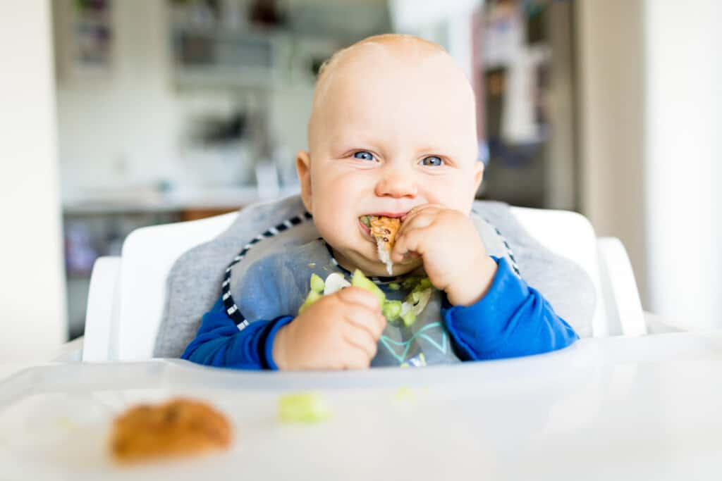 happy baby led weaning baby at daycare eating his lunch